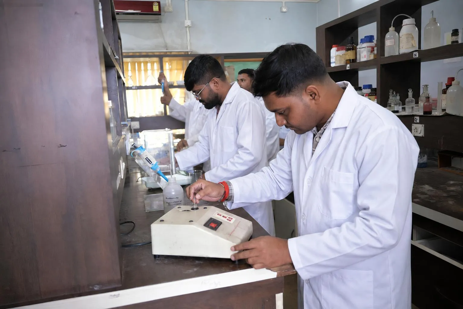 Students using a micropipette and laboratory instruments in a chemistry laboratory